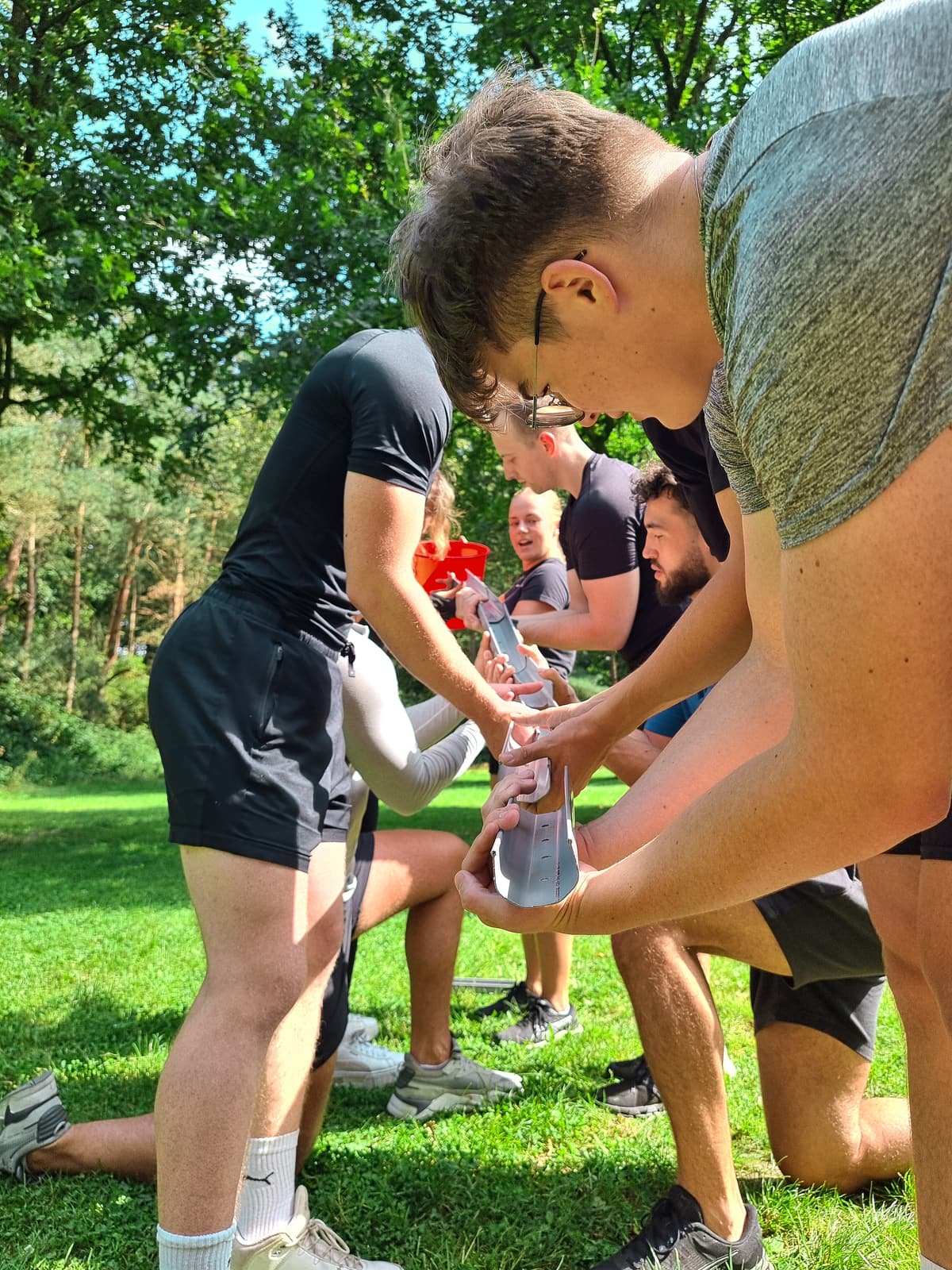 Collega's geven samen water door via goten tijdens een teambuildingopdracht van Het Krachtkantoor